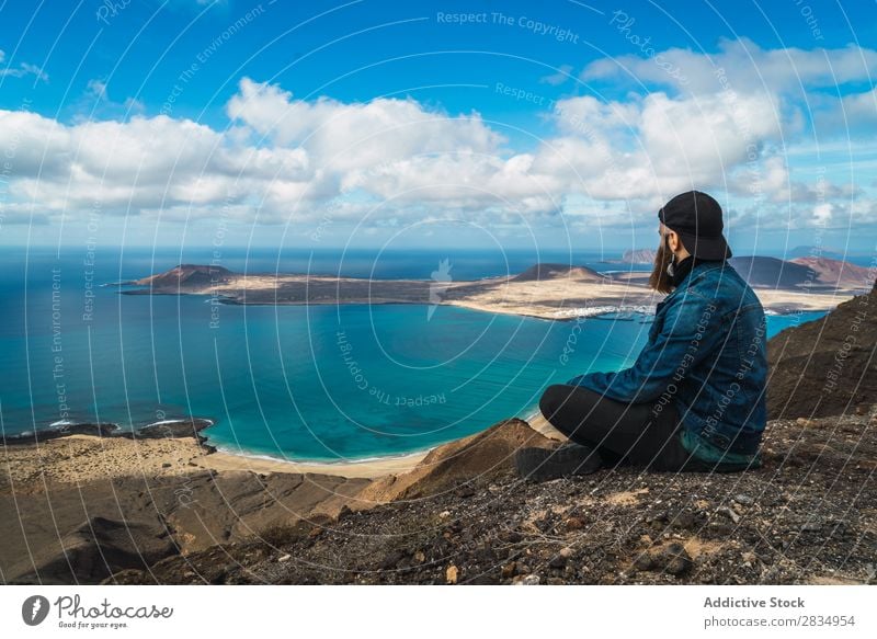 Man with looking away at seaside Tourist Ocean Island Sit Clouds Aircraft Nature Landscape Natural Rock Stone Lanzarote Spain Vantage point Vacation & Travel