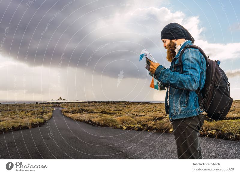 Tourist man with map Field Map Navigation Lost Backpack Stand Rest Clouds Nature Landscape Natural Lanzarote Spain Vantage point Vacation & Travel Tourism Trip
