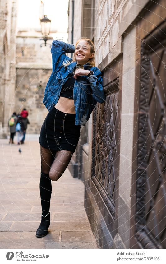 Laughing woman posing near wall Stand Wall (building) Woman Easygoing Street City Town Youth (Young adults) Beautiful Looking into the camera Beauty Photography
