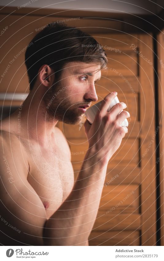 Young man drinking from a cup Man Cup Drinking Morning Considerate Looking away Pensive Mug Hot sleepy Think Breakfast Lifestyle Home Portrait photograph