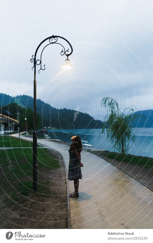Woman looking on lamppost Walking Lake Looking up Lamp post Evening Coast Vantage point Nature Water Landscape Summer Blue Green Beautiful Scene