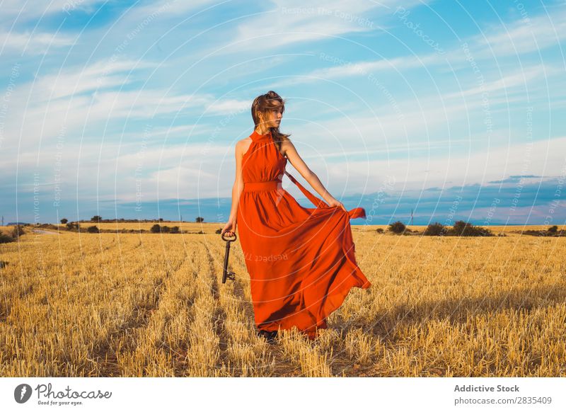Pretty woman with big key on field Woman Beautiful Player Performance pretty Field Dress Youth (Young adults) Nature Summer Happiness Portrait photograph