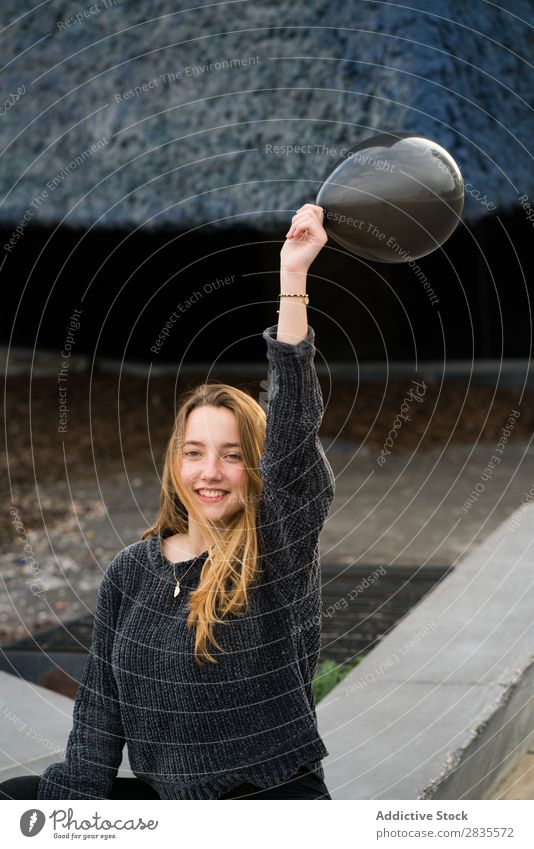 Young girl in Barcelona woman pretty balloon black laughing cheerful mouth opened parking lot lines ground yellow portrait young beautiful hair female sweater