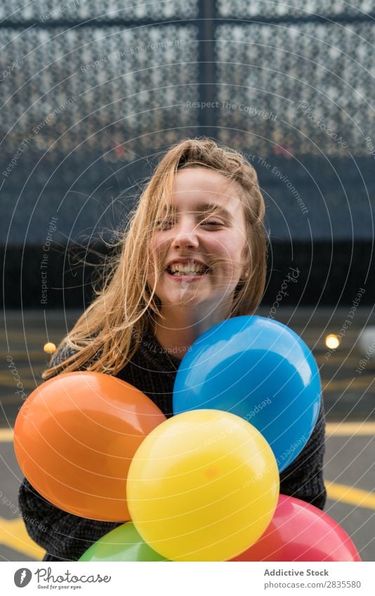 Young girl in Barcelona woman balloons running jumping fun bunch colorful bright pretty cheerful happy joyful smiling happiness reflection young beautiful