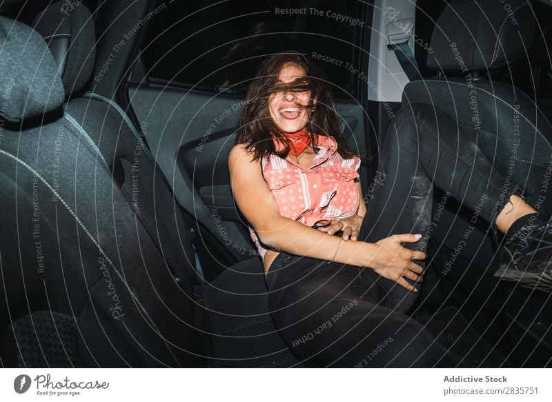 Woman in light posing in car Provocative Car Posture Attractive covering mouth Style Interior shot Dark Self-confident Vehicle Easygoing Night Passenger Light