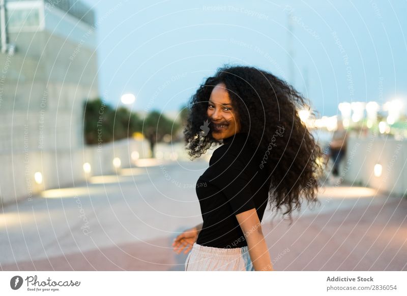 Playful girl posing on street Woman spinning round Cheerful Ethnic To enjoy waving hair Expressive Street in motion facial Wonderful Curls tenderness Posture