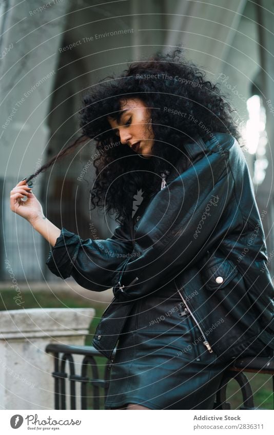 Curly woman posing in city Woman Attractive City fashionable Brunette Jacket Fence Fashion Youth (Young adults) Beautiful pretty Street Model Style Hair