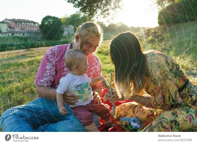 Happy family in park Mother Child Park Lawn Green Sunbeam Human being Woman Happiness Summer Lifestyle Love same gender parents Homosexual Couple