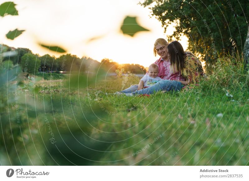Lesbian family with child on lawn Mother Child Park Lawn Green Sunbeam Happy Human being Woman Happiness Summer Lifestyle Love same gender parents Homosexual