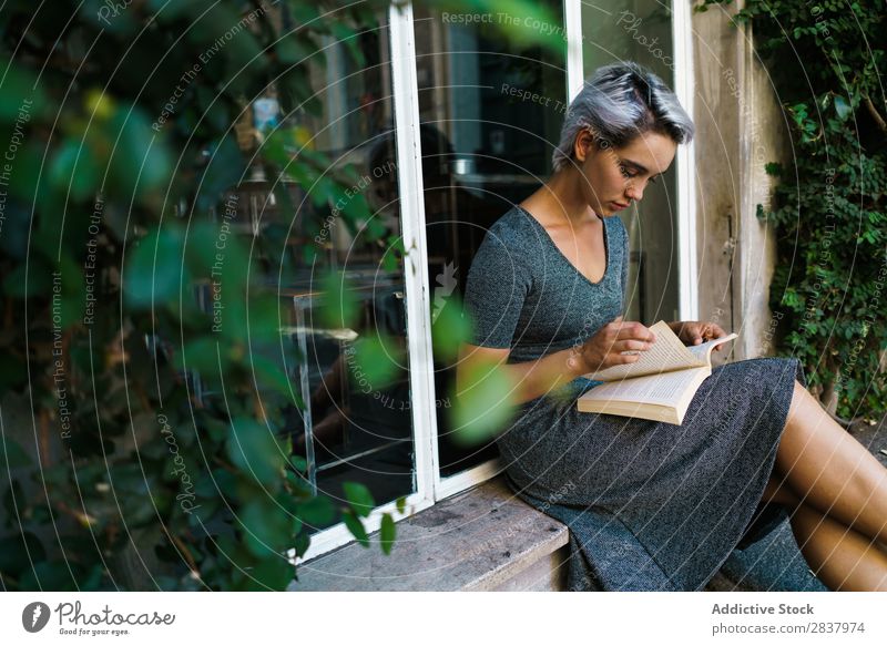 Woman reading book at window Book Street Sit Window Windowsill Beautiful Girl Youth (Young adults) Student pretty Adults Smiling City Beauty Photography