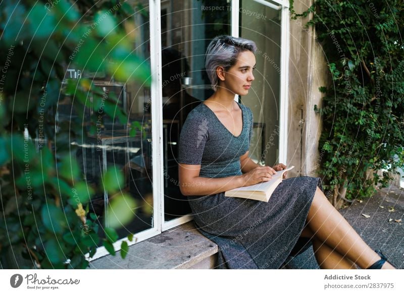Woman reading book at window Book Street Sit Window Windowsill Beautiful Girl Youth (Young adults) Student pretty Adults Smiling City Beauty Photography