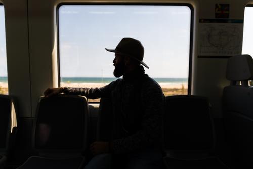 Silhouette of man in train Man Ride Railroad Hat Beard Vacation & Travel Transport Human being Passenger Trip traveler Seat wagon Sit Vehicle Speed Tourist