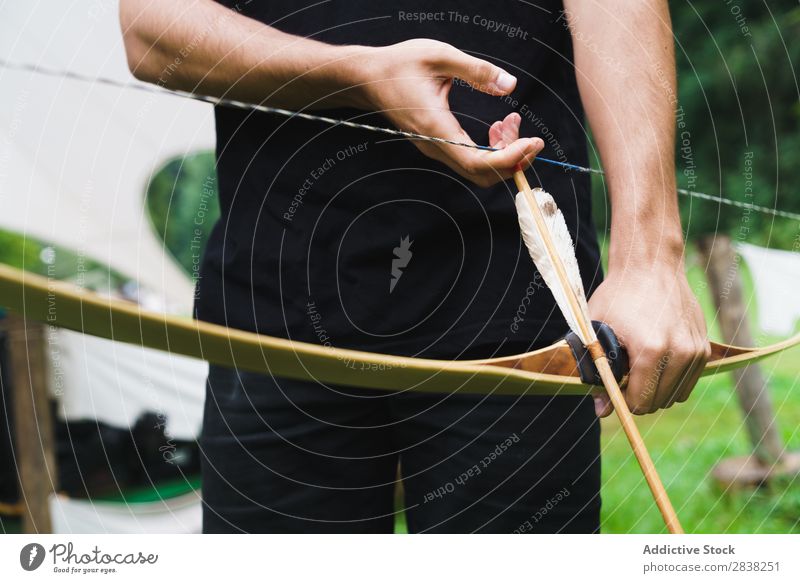 Crop man practicing archery in school Man Archery Aim Concentrate Action Competition Success Fitness Stand challenge focus Exterior shot Bow Arrow Weapon School