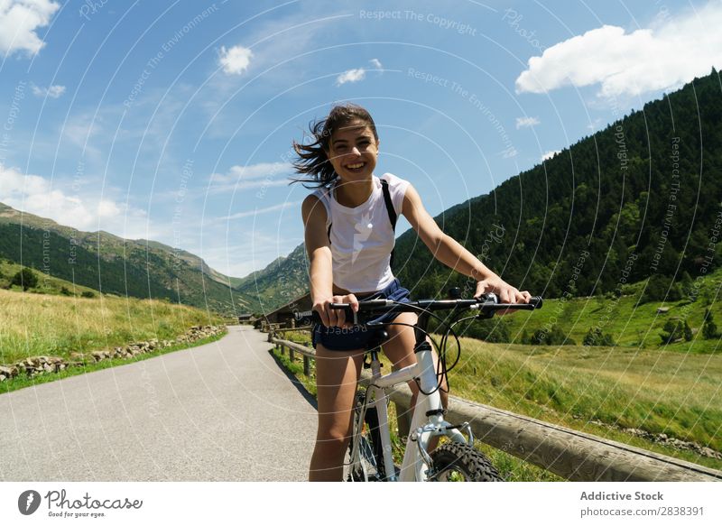 Woman riding bike looking at camera Athletic Bicycle Cheerful Smiling Looking into the camera Sports Cycle Girl Action Lifestyle Cycling Human being workout
