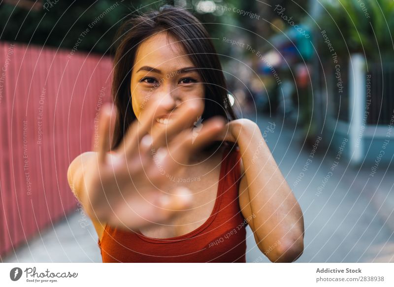 Cheerful woman gesturing stop Woman pretty asian Youth (Young adults) Smiling hiding Stop Gesture Looking into the camera Street Town Beautiful