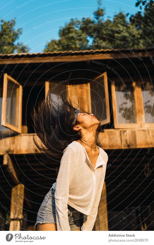 Pretty woman shaking hair at house Woman pretty asian Youth (Young adults) Hair Brunette Joy Wood House (Residential Structure) Sunbeam Beautiful