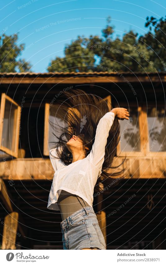 Pretty woman posing near house Woman pretty asian Youth (Young adults) Hair shaking Brunette Joy Wood House (Residential Structure) Sunbeam Beautiful