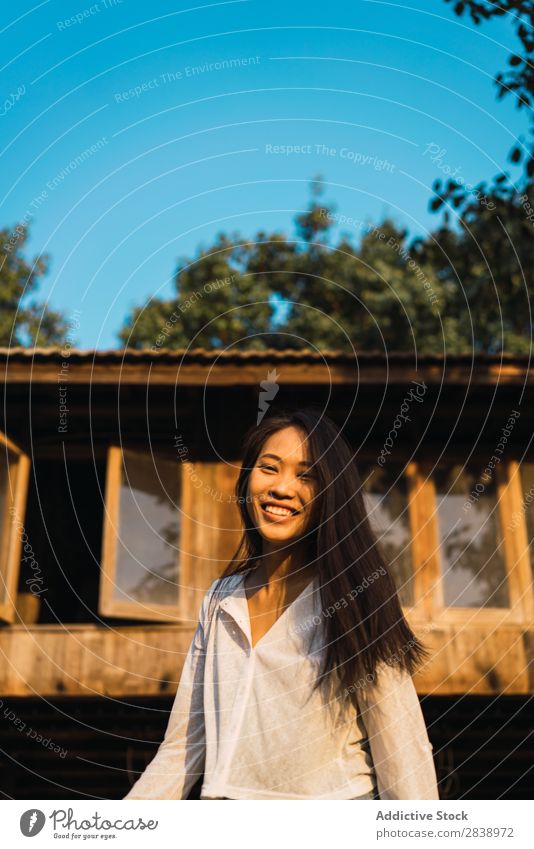 Pretty woman posing near house Woman pretty asian Youth (Young adults) Hair Brunette Joy Wood House (Residential Structure) Sunbeam Beautiful
