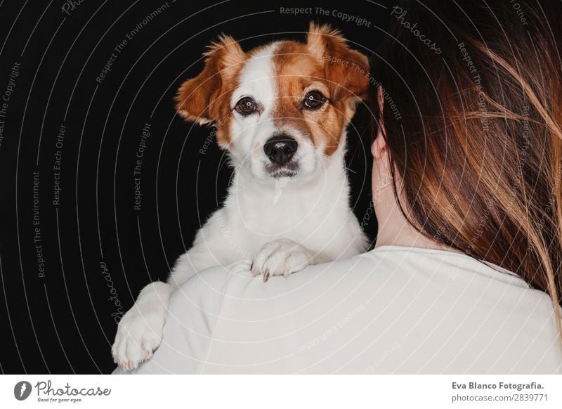 young woman and her cute dog. black background Happy Woman Adults Friendship Animal Pet Dog Smiling Love Dark Together Small Cute Brown Black White Emotions