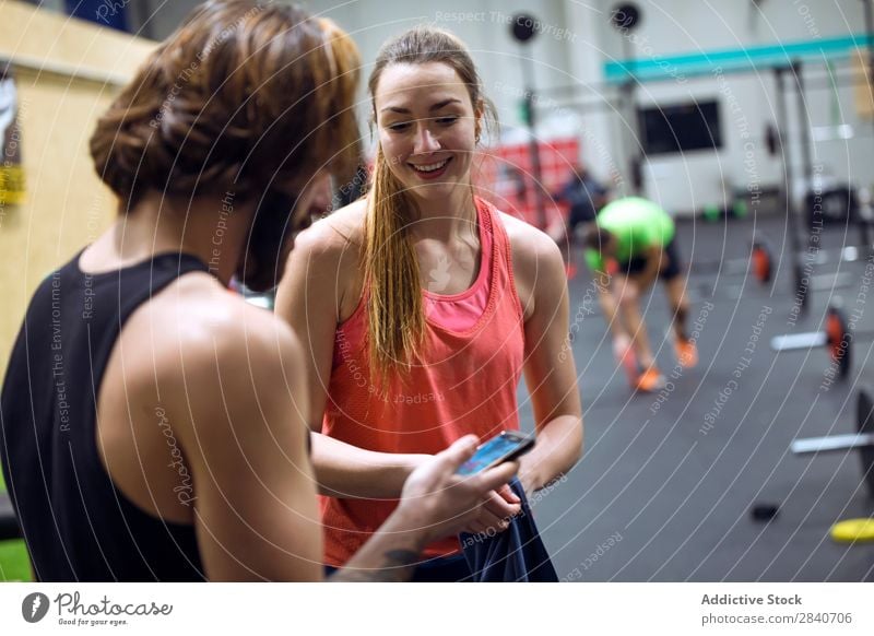 Cheerful fit people with phones in gym Human being Gymnasium workout Athletic Fitness Practice Lifestyle PDA using browsing Sports Healthy Sportswear Action