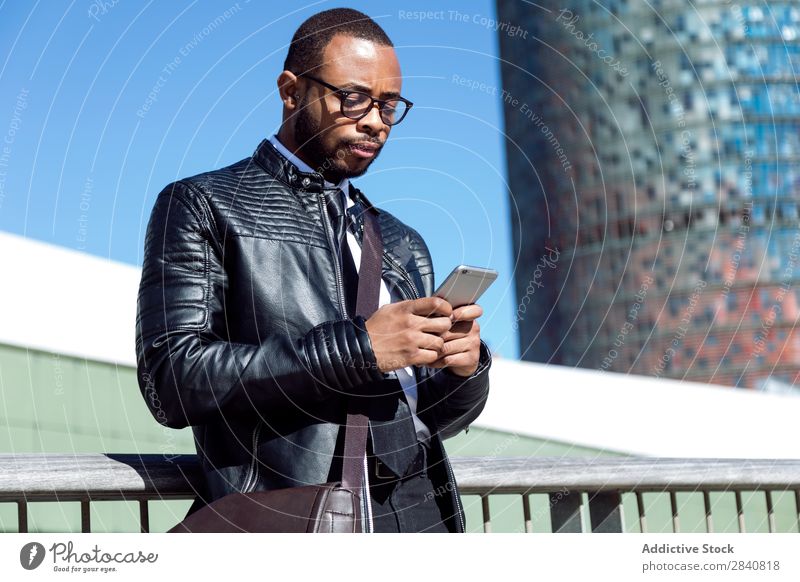 Young male typing on phone Man Successful Telephone Style Self-confident Businessman Technology using browsing Businesspeople African Black handsome Clothing