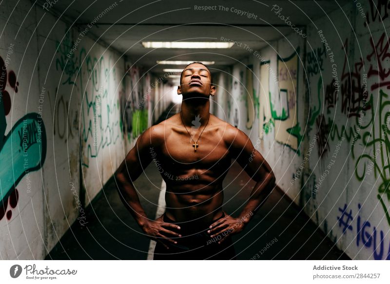 Cheerful sportsman posing underground Man grungy Athletic Musculature Indicate shirtless Sports African Graffiti Underground handsome Torso Model Body Posture