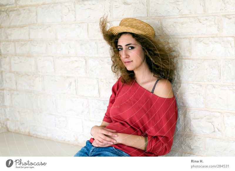 commemoration Young woman Youth (Young adults) 1 Human being Wind T-shirt Jeans Hat Hair and hairstyles Brunette Long-haired Curl Think Sit Beautiful Red White