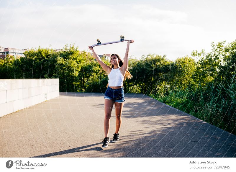 Happy girl holding skate above head Woman Skateboard Cheerful Freedom Youth (Young adults) Park Rural Hipster Skateboarding Nature Relaxation Style Beautiful