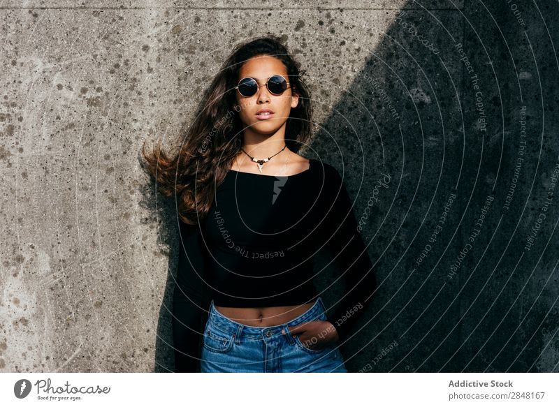 Charming teen in sunlight Woman Town Style Clothing Self-confident Youth (Young adults) Sunglasses Hipster Curly hands in pockets Posture human face