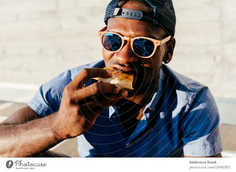 Young black man eating pizza at street Man Style Pizza Street Portrait photograph Black enjoying Food Lunch Lifestyle Student Hip & trendy handsome