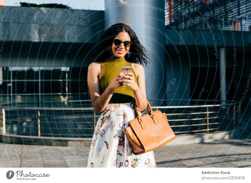 Smiling woman with smartphone in city Woman PDA City Elegant texting using browsing Walking Communication Youth (Young adults) Lifestyle Beautiful Girl Mobile