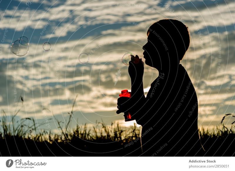 Silhouette of boy blowing soap bubbles Boy (child) Soap bubble Nature Blow Vacation & Travel Joy Meadow Bright Recklessness Entertainment Freedom Expression