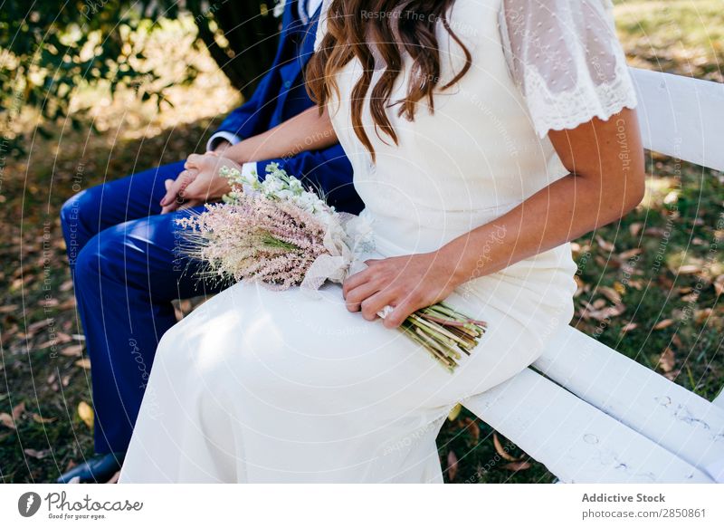 Crop bride and groom on bench Bride Groom Bench Couple romantic Feasts & Celebrations Together holding hands Summer Flower Exterior shot Engagement Love Wedding