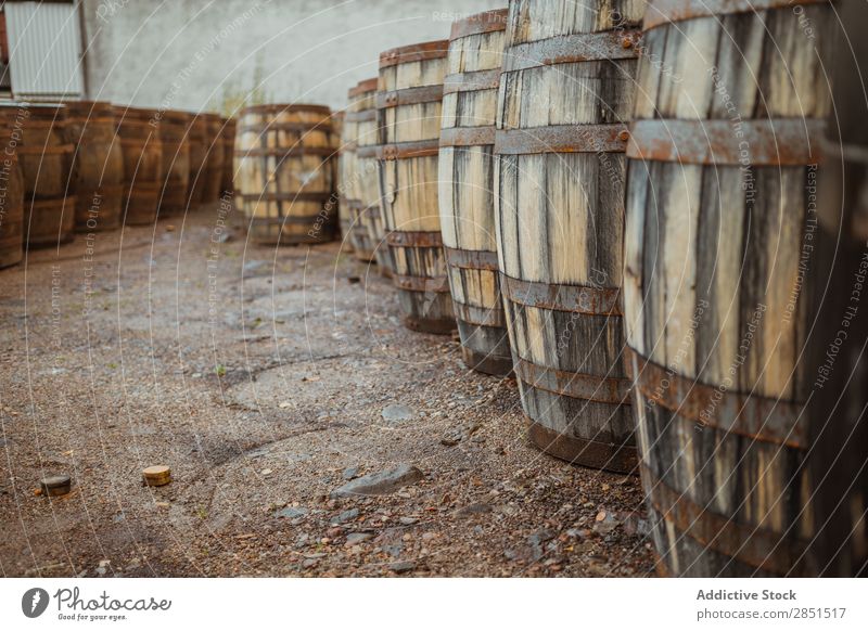 Wooden barrels on stone surface Arranged Winery Storage Production Factory Warehouse Alcoholic drinks Beverage Stack Collection Rustic Arrangement Pavement