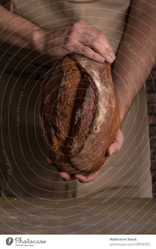 Man holding a freshly baked loaf of bread Baking Bakery Bread Breakfast carbohydrate Cut Dark Flour Food Fresh Hand Self-made home-baked Home-made Rustic Seed