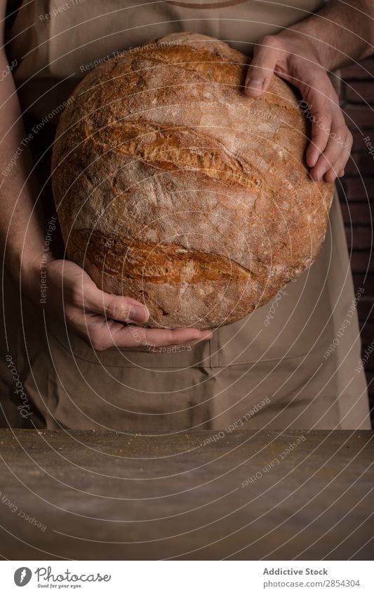 Man holding a freshly baked loaf of bread Baking Bakery Bread Breakfast carbohydrate Cut Dark Flour Food Fresh Hand Self-made home-baked Home-made Rustic Seed