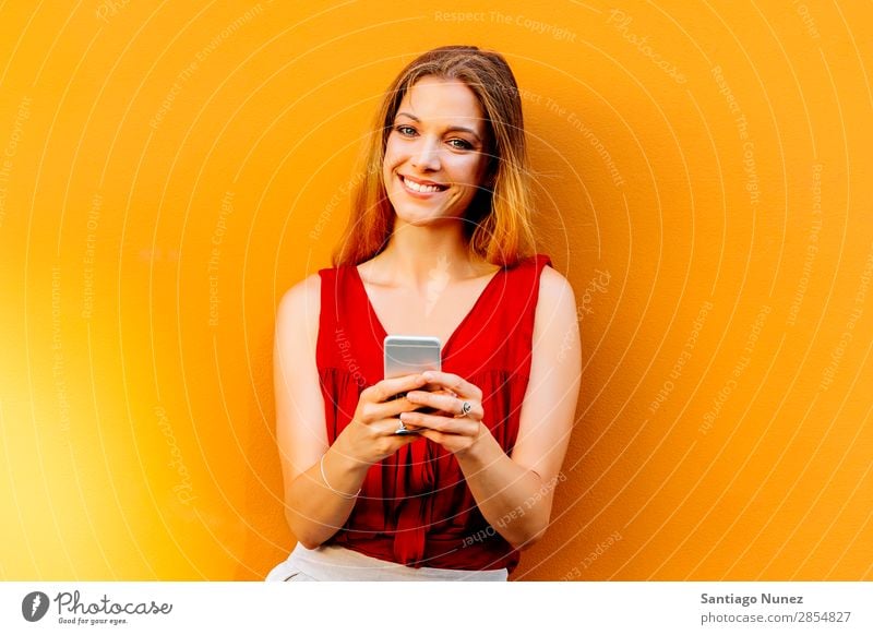 Portrait of beautiful young woman using mobile phone in the street. Woman Telephone Happy Mobile Youth (Young adults) Wall (building) Cellphone