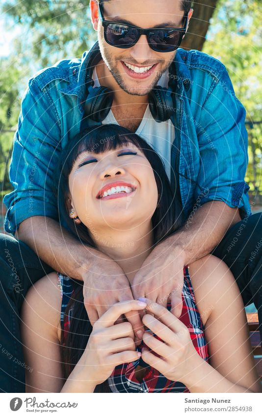 Portrait of happy beautiful couple isolated on street Adults Affection asian Attractive Bench Boy (child) boyfried boyfriend Easygoing Caucasian Chinese