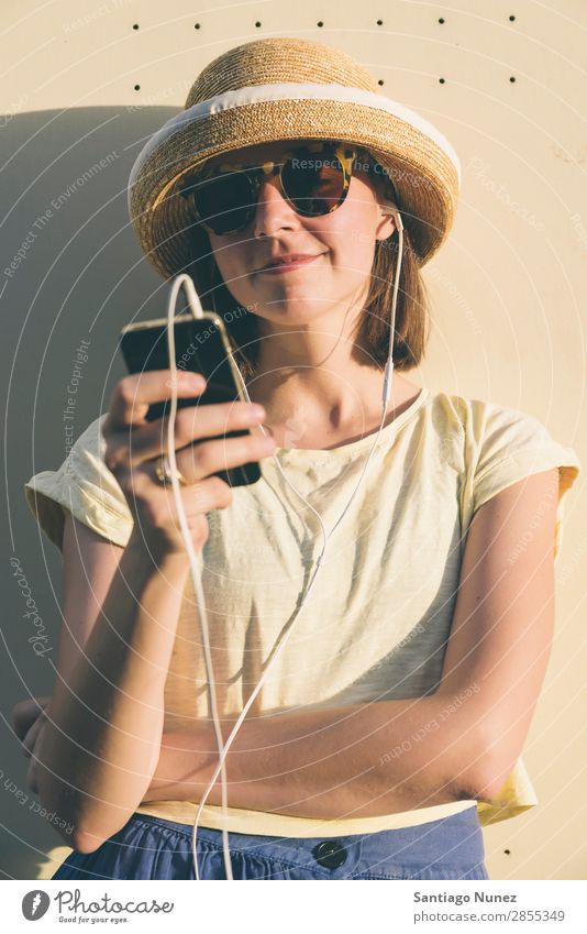 Beautiful young hipster Caucasian woman with smartphone and earphones, texting and listening to music. Easygoing Solar cell Cellphone Chat Headphones Woman Girl