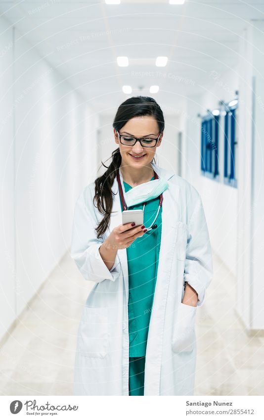 Beautiful doctor writting on cellphone at hospital. Attractive Considerate Caucasian Cellphone Cheerful clinic clinician Communication Doctor Email Woman