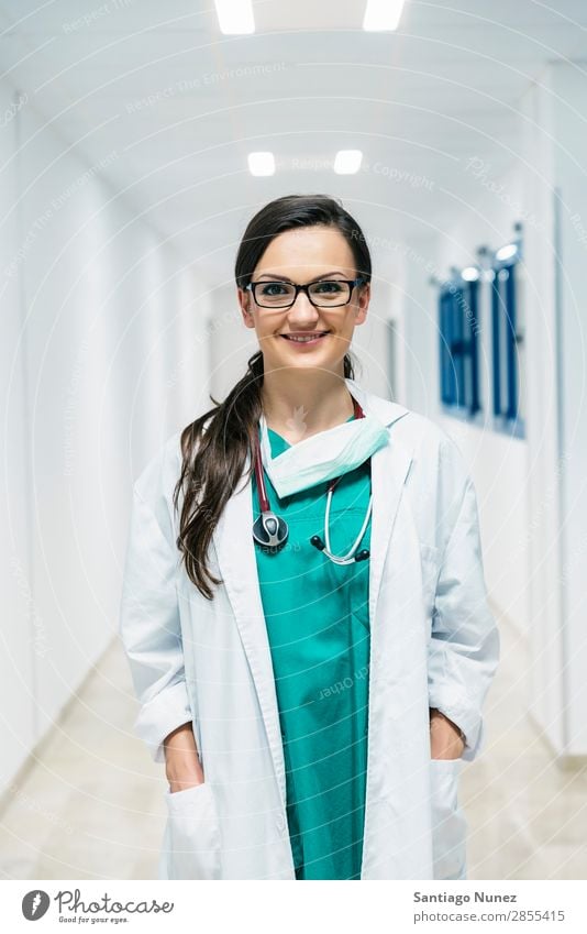 Smiling beautiful doctor at hospital. Standing. Arm Attractive Background picture Beautiful Considerate Caucasian Cheerful clinic clinician Doctor Equipment