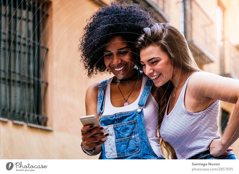 Beautiful women using a mobile in the Street. Woman Friendship Youth (Young adults) Happy Summer Human being Joy Mobile PDA Telephone Solar cell Communication