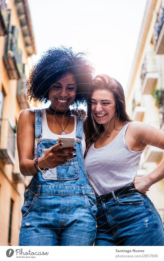 Beautiful women using a mobile in the Street. Woman Friendship Youth (Young adults) Happy Summer Human being Joy Mobile PDA Telephone Solar cell Communication