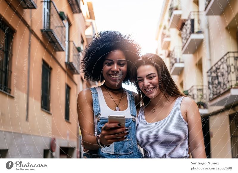 Beautiful women using a mobile in the Street. Woman Friendship Youth (Young adults) City Happy Summer Human being Joy Mobile PDA Telephone Solar cell