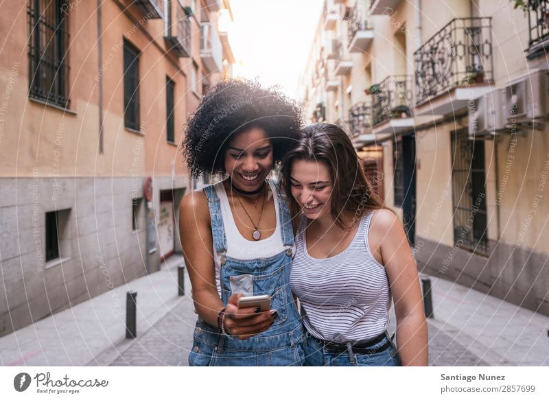 Beautiful women using a mobile in the Street. Woman Friendship Afro Youth (Young adults) Happy Summer Human being Joy Mobile PDA Telephone Solar cell