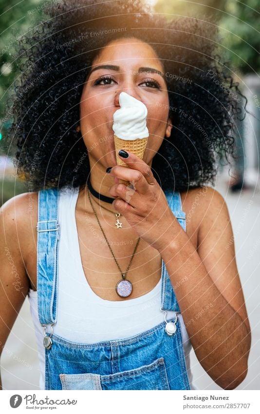 Portrait of a beautiful woman eating one ice cream. Woman Black African Afro Ice cream Cream Eating Lick Summer Hot Suck Human being Portrait photograph City