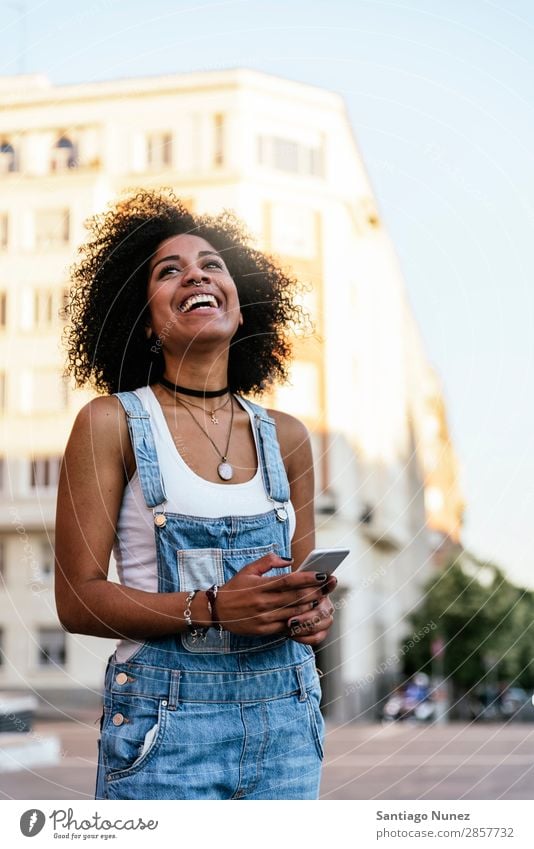 Beautiful woman using mobile in the Street. Woman Telephone Black African Mobile PDA texting Communication Afro Human being Portrait photograph City