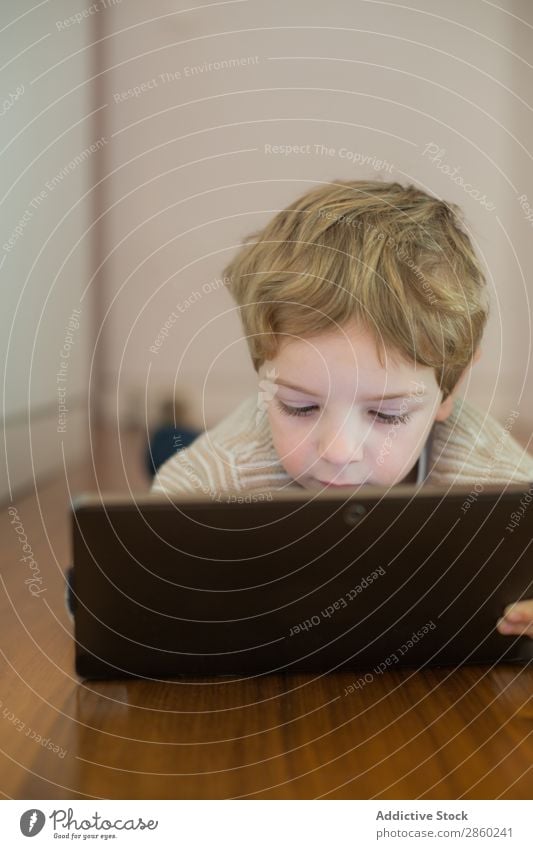Blonde and cute boy playing with tablet Boy (child) Caucasian Child Computer Day Digital Electronic indoor Lifestyle Playing Screen Tablet computer Technology