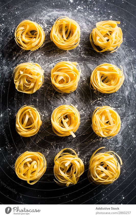 Raw tagliatelle on dark table Background picture Blackboard Board carbohydrate Dough Dry Egg Flour Food Fresh Healthy Home-made Italian Kitchen Deserted noodle