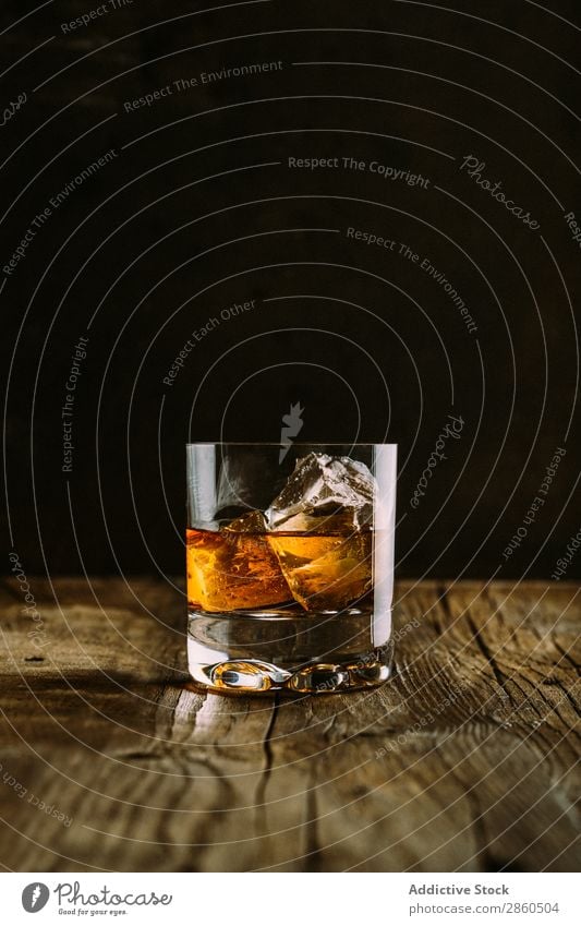 Glass of whiskey on a wooden table Alcoholic drinks Amber Background picture Bar barman bartender Beverage Bottle Bourbon Brandy Cognac Dark Drinking Gold Ice